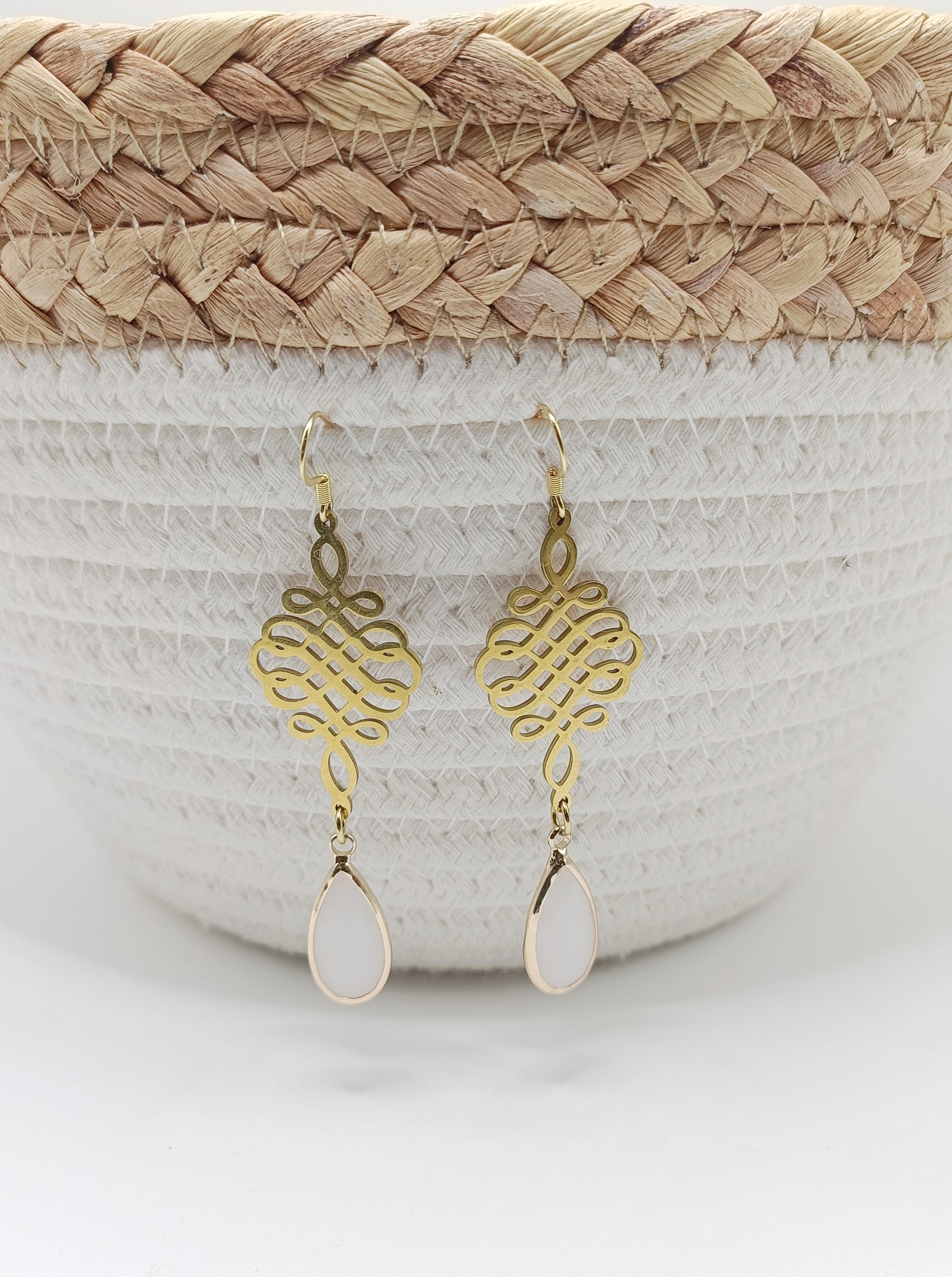 Rosny, les boucles d'oreilles dorées pendantes, style noeuds chinois et perles gouttes blanches en verre facetté