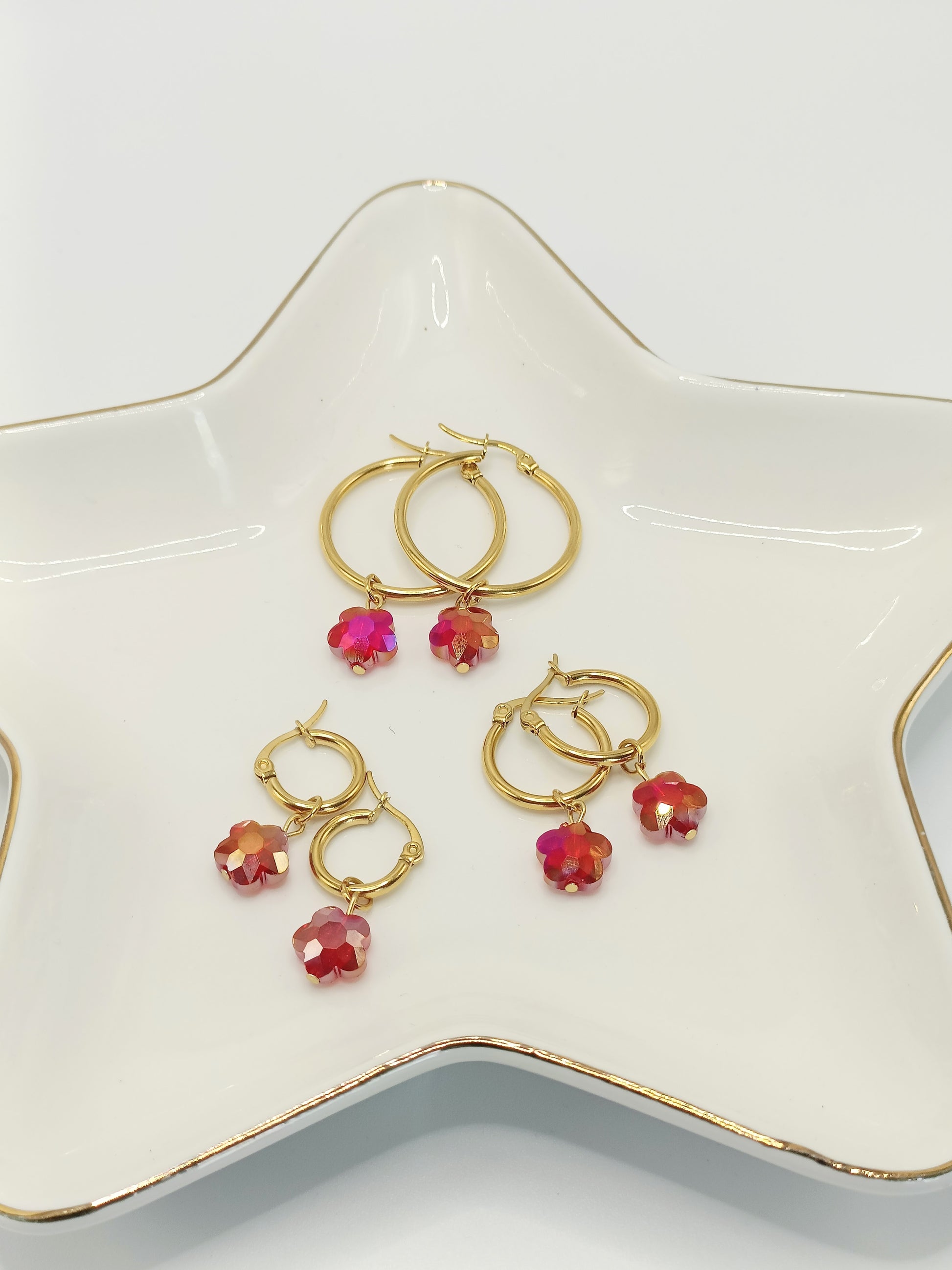 Différentes tailles des créoles Cosima dorées 18k avec breloques fleurs rouges en cristal