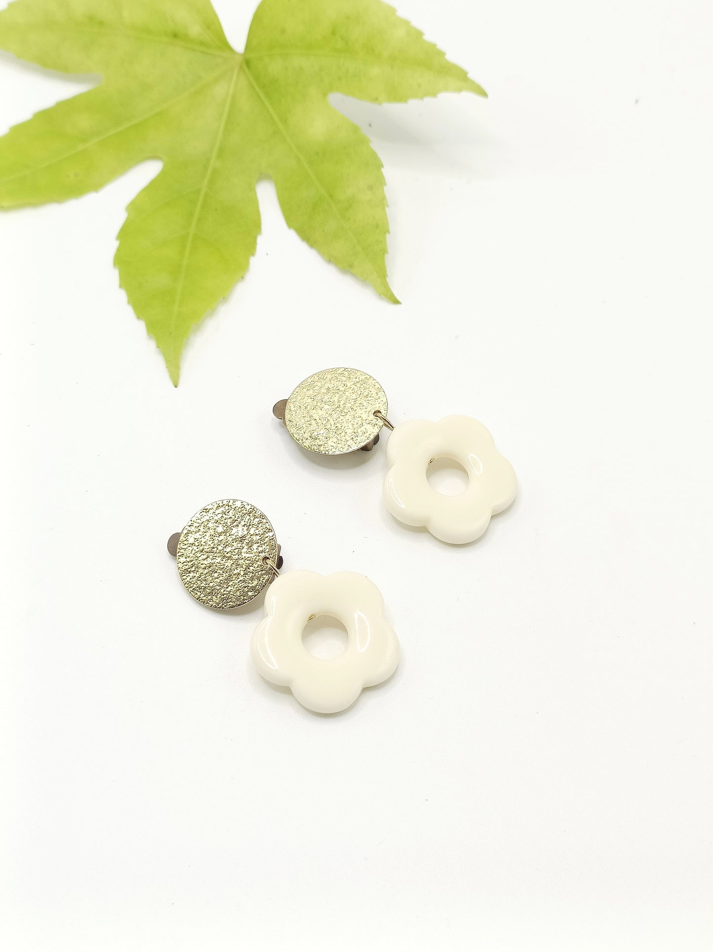 Flora, les boucles d'oreilles clips dorés martelés et fleurs blanc cassé en acrylique