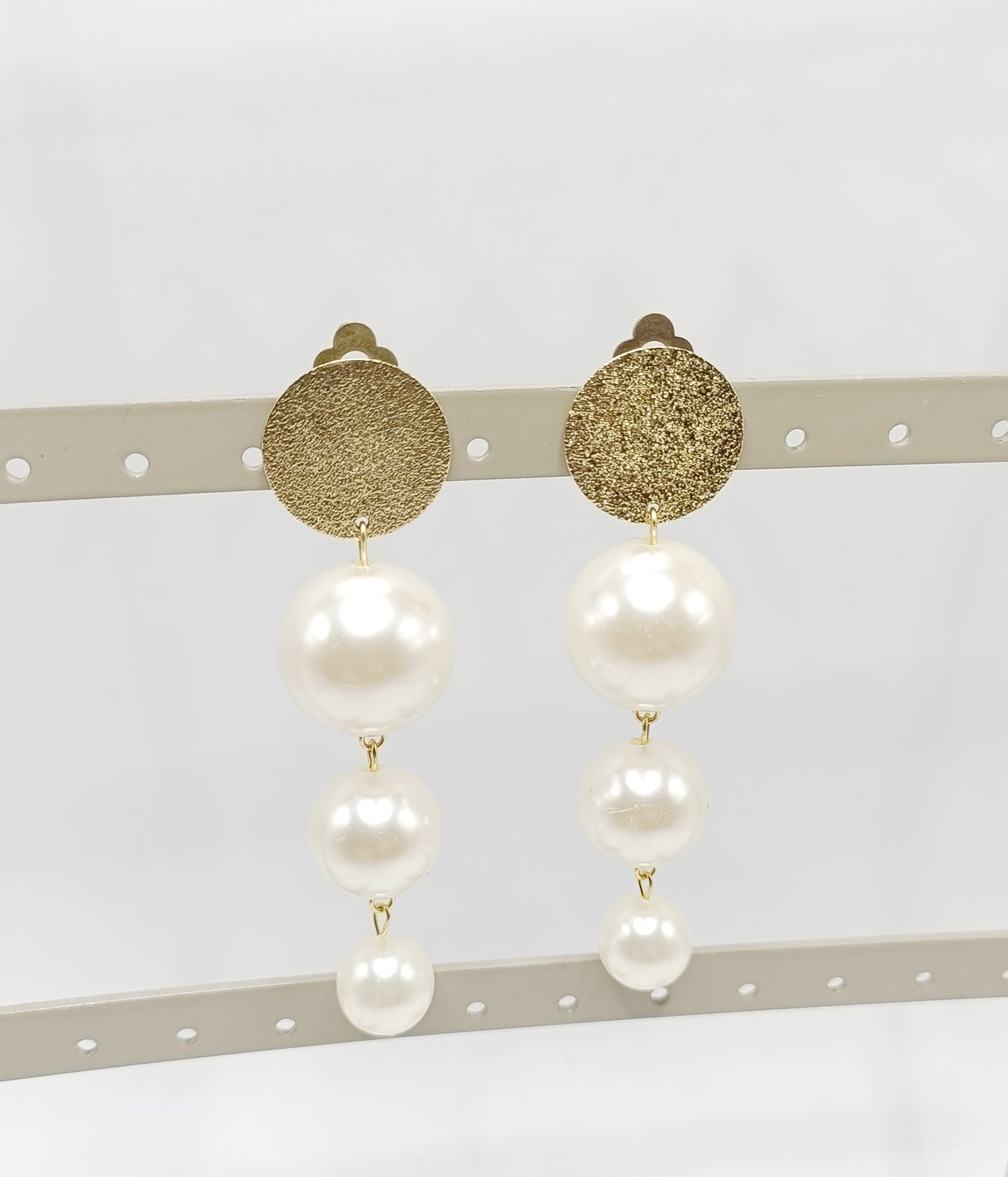 Les Cascades, grandes boucles d'oreilles clips dorés et trois perles blanches de taille différente en chute