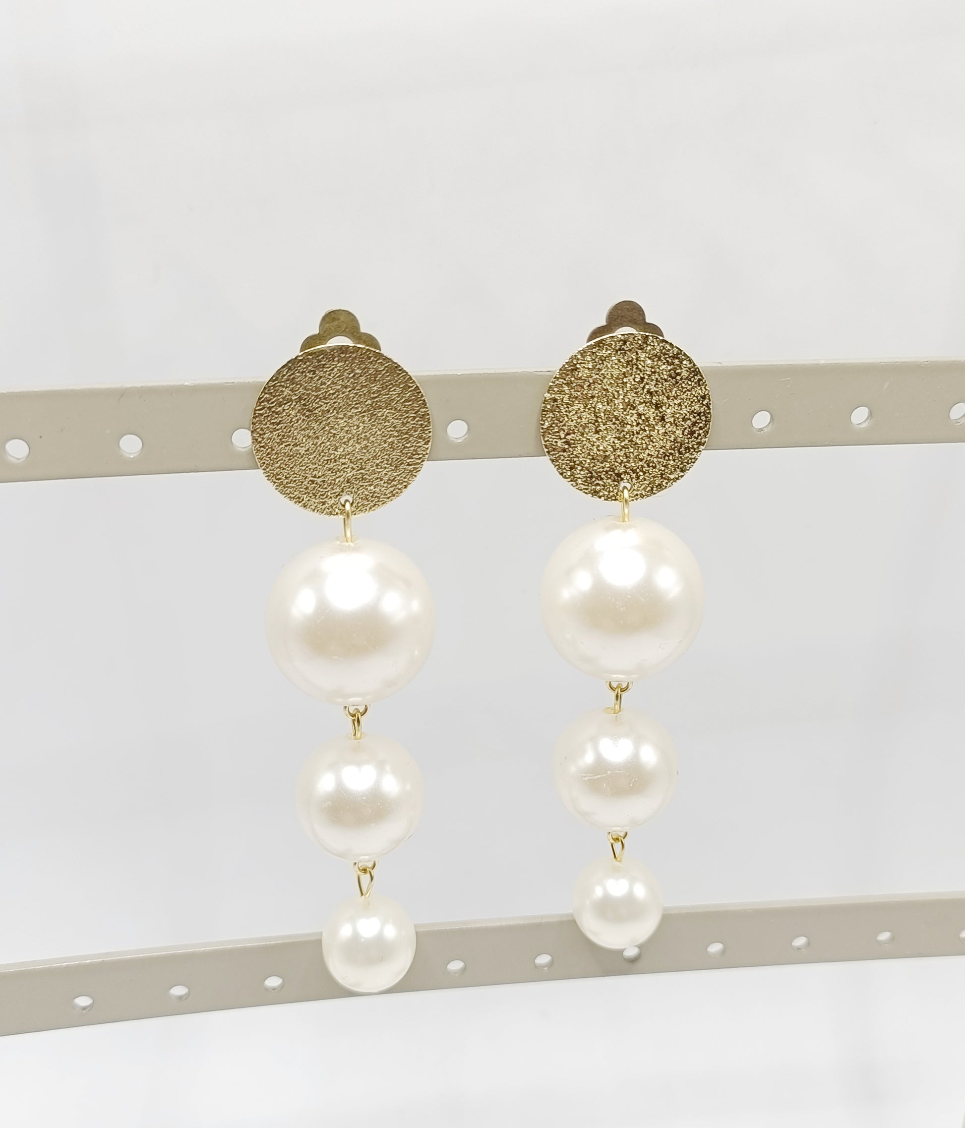 Les Cascades, grandes boucles d'oreilles clips dorés et trois perles blanches de taille différente en chute