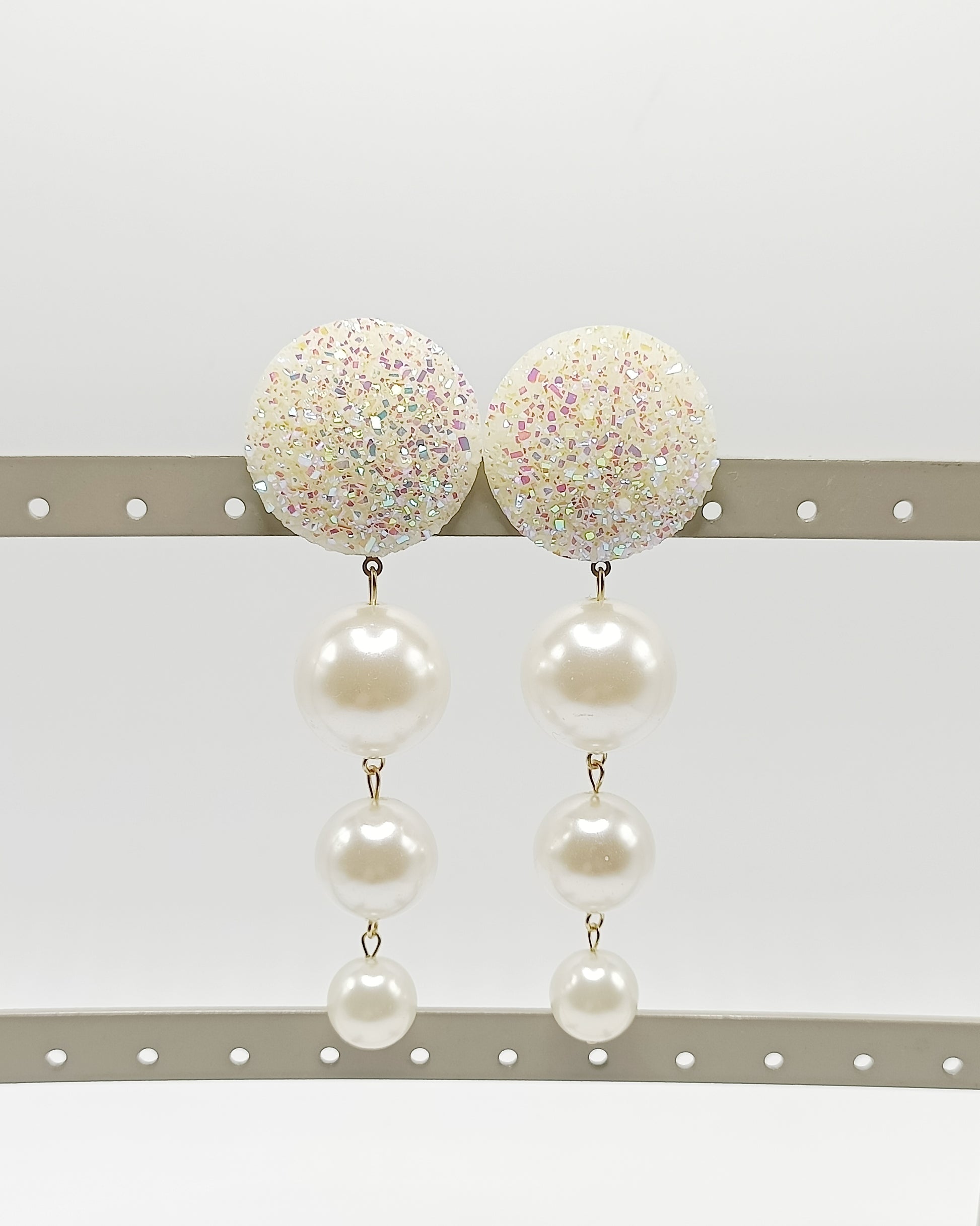 Les Cascades, grandes boucles d'oreilles clips brillants blanc pailletés légèrement rosés et trois perles blanches de taille différente, en chute, très légères