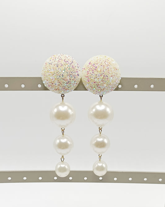 Les Cascades, grandes boucles d'oreilles clips brillants blanc pailletés légèrement rosés et trois perles blanches de taille différente, en chute, très légères