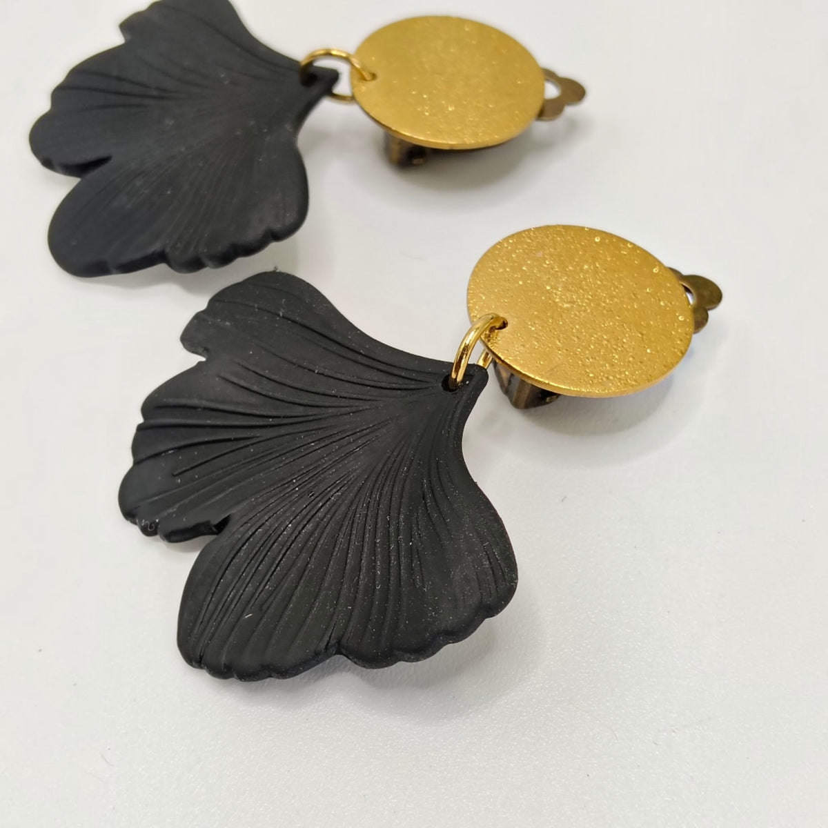 Lizzi, les boucles d'oreilles clips indolores dorés matelés en acier inoxydable et feuilles gingko noires très légères
