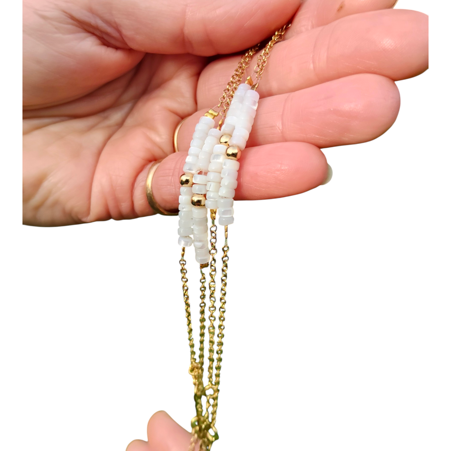 Lucien, le bracelet fin doré en acier inoxydable et ses petites rondelles en nacre blanche et perle dorée en acier inoxydable