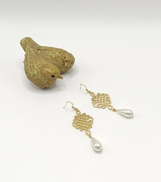 Rosny, les boucles d'oreilles dorées pendantes, style noeuds chinois  et perles gouttes blanches en verre, en percées ou clips