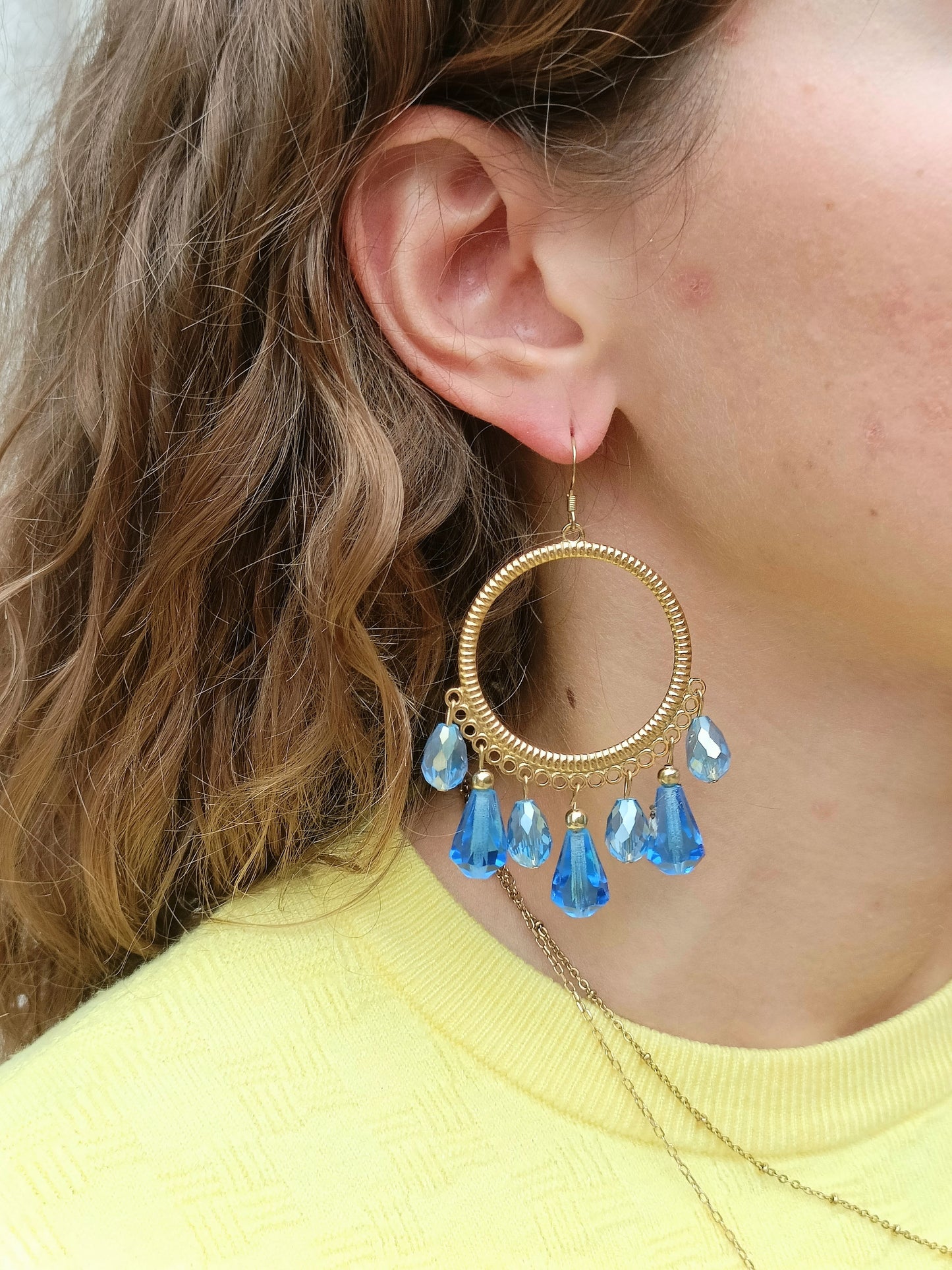 Ysambre, les grandes boucles d'oreilles rondes dorées or fin et perles gouttes bleues en cristal et verre facetté, disponibles en percées ou clips